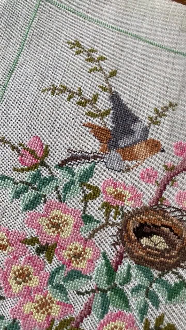 ピンクと緑の鳥と鳥の巣を描いたリネンのタペストリーに施された