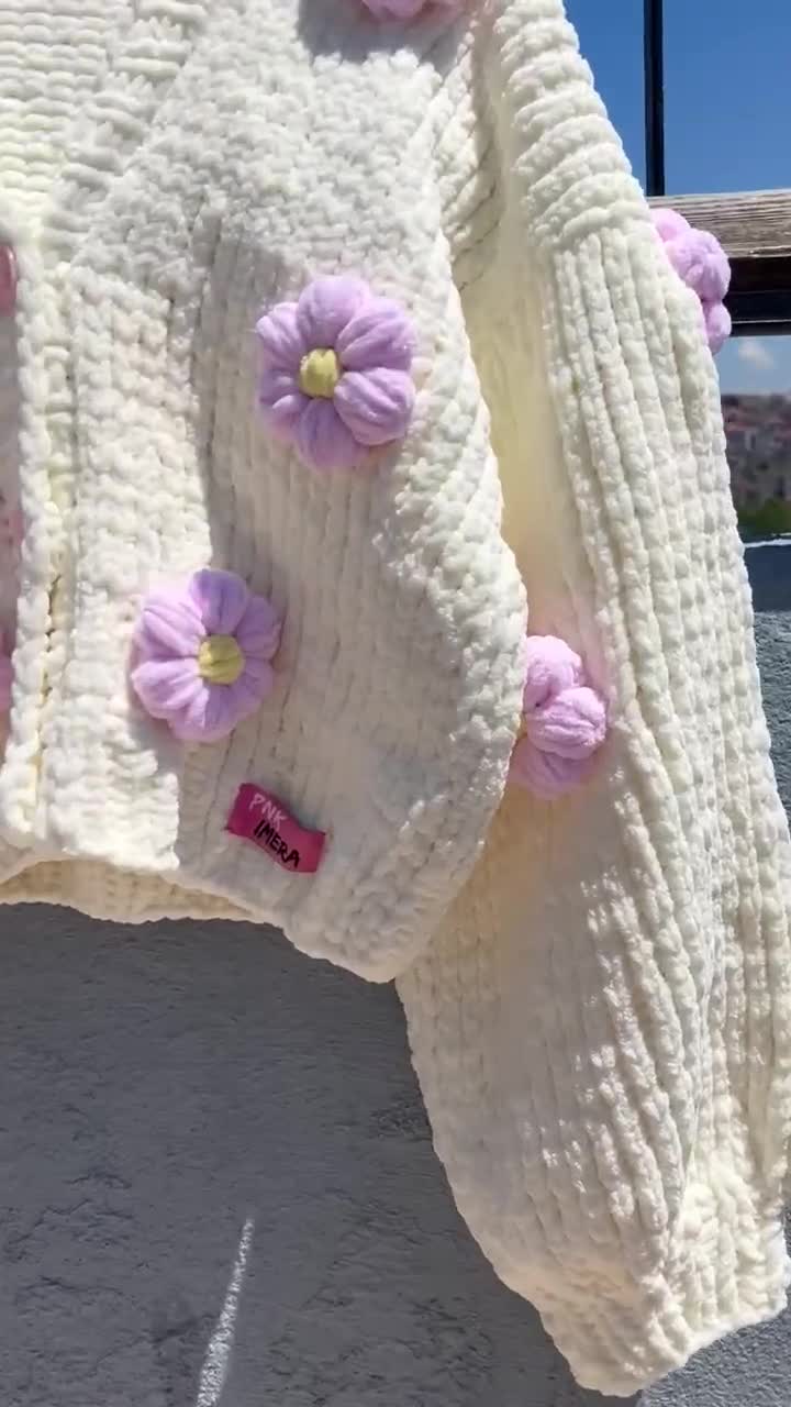 手編みのクリーム色のカーディガン、立体的なピンクの花柄、チャンキー