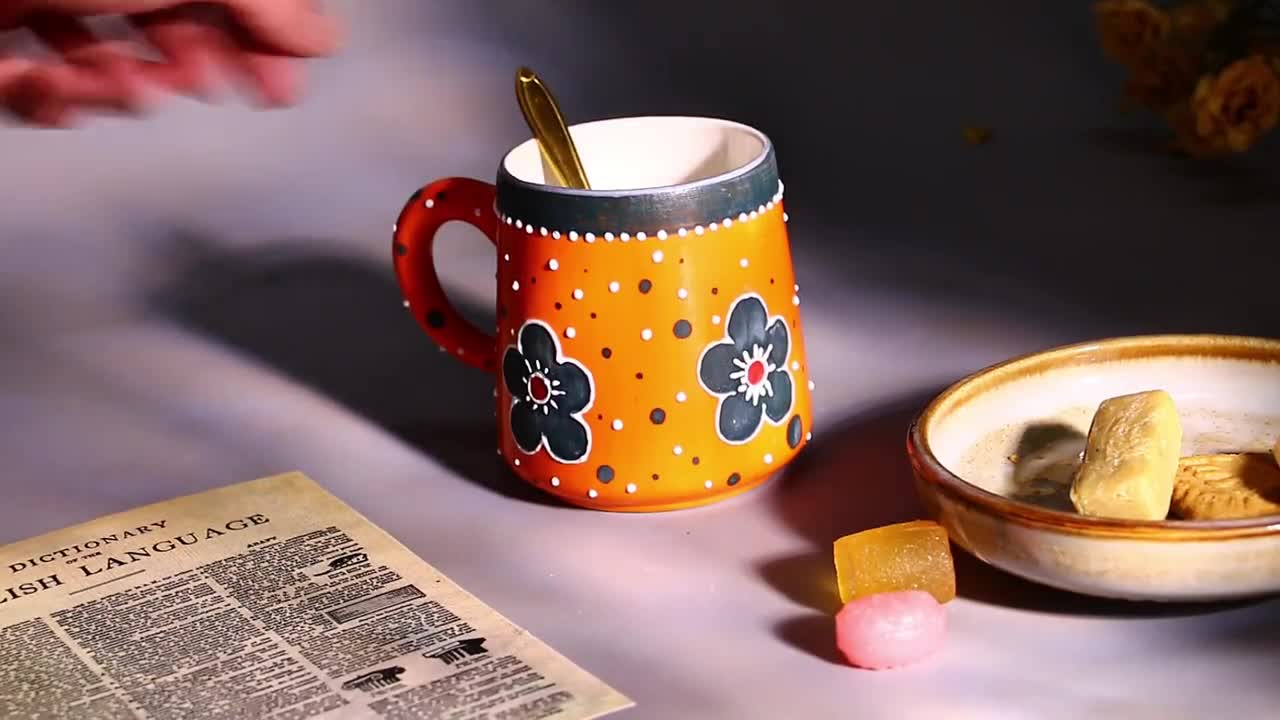 大胆なオレンジ色の陶器マグカップ - 手描きの花と水玉模様のデザイン