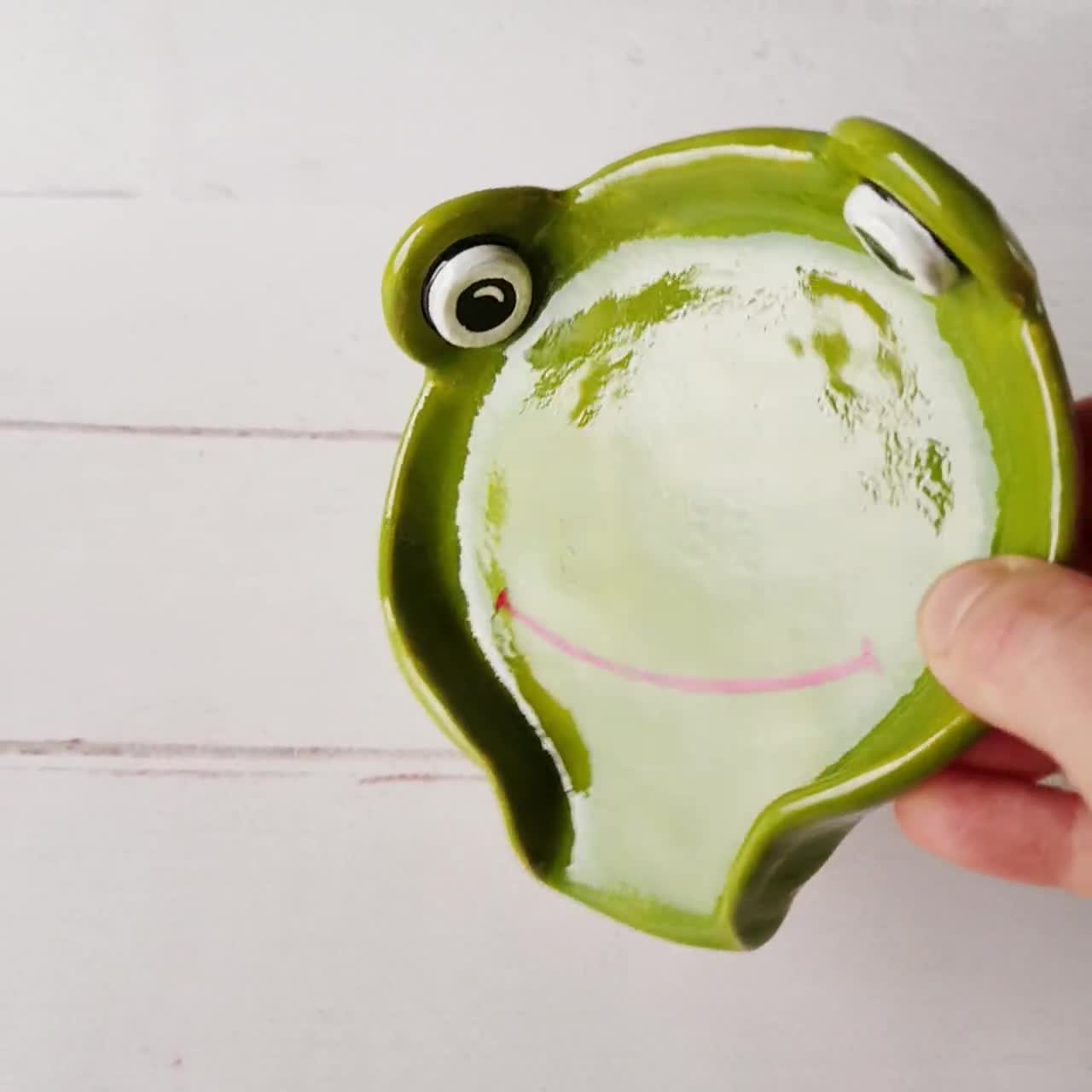 Frog spoon rest has a raised spotted green frog on aqua swirl glaze. It is  handmade ceramic in a round bowl shape with a notch to catch any gloop  keeping your stove