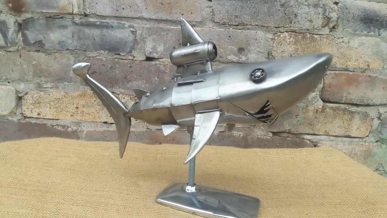 Figurina di metallo di uno squalo su un supporto Squalo Steampunk