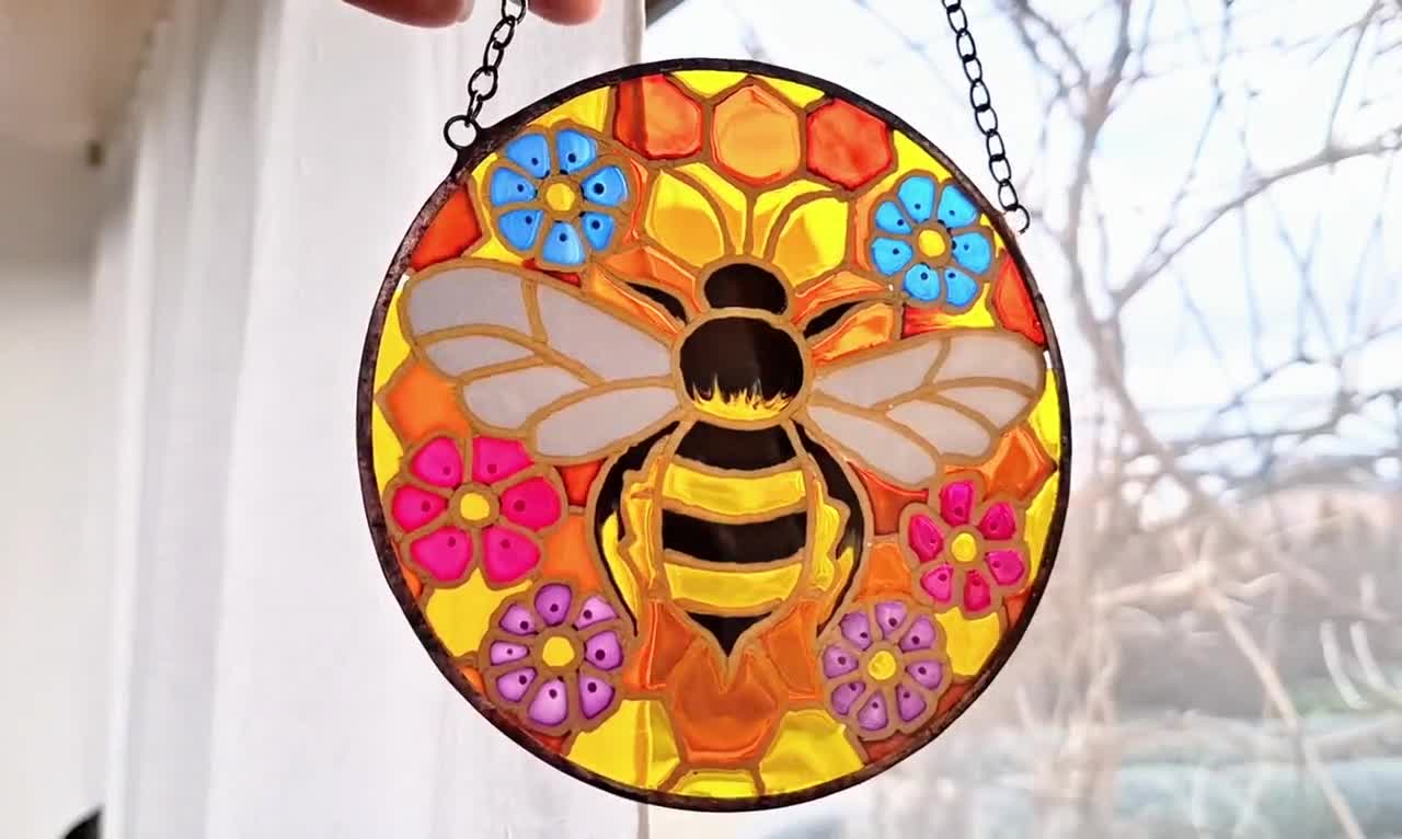 手描きの蜂と花のステンドグラスサンキャッチャー。ハニカム模様の窓