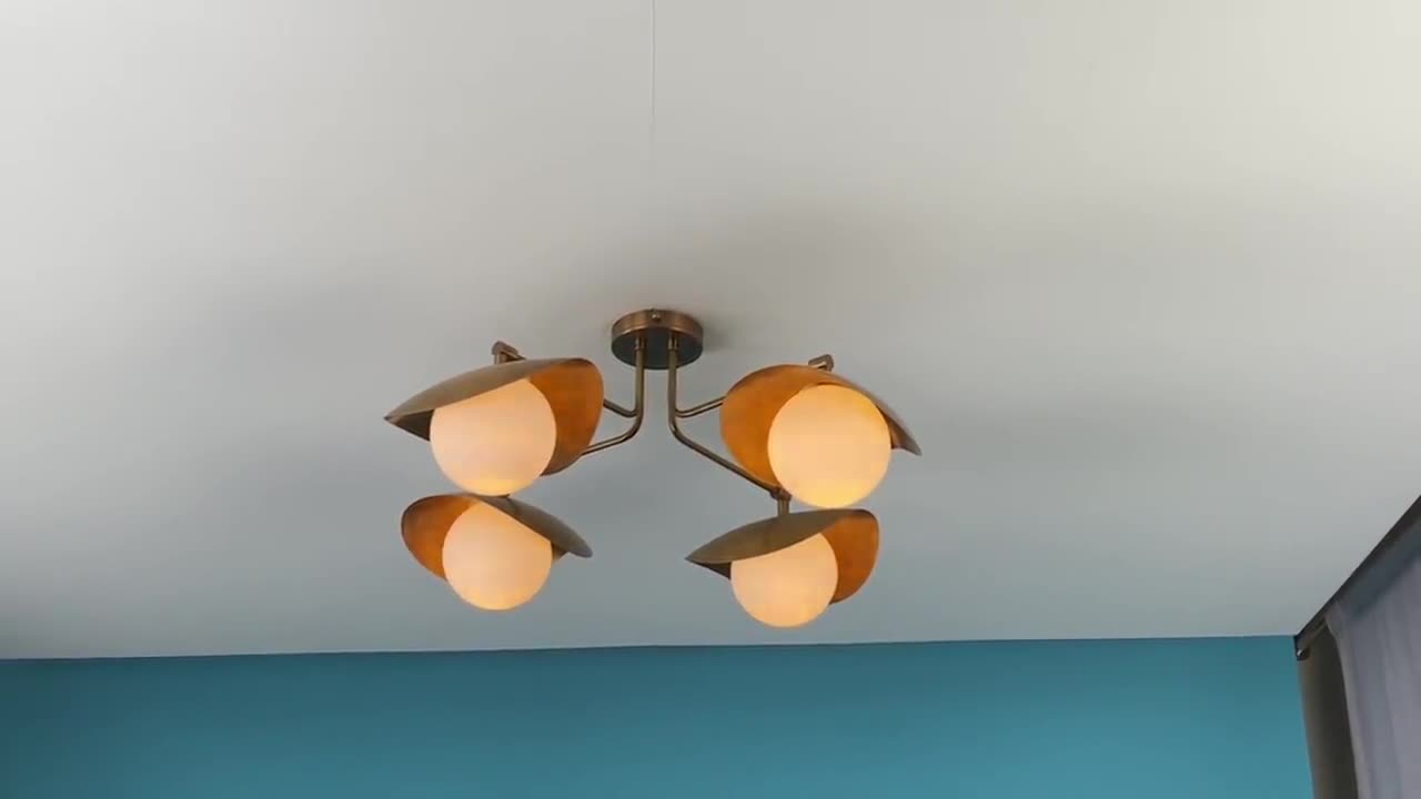 Lámpara de techo empotrada de estilo moderno de mediados de siglo con pantallas curvas de latón y globos de vidrio. video poster