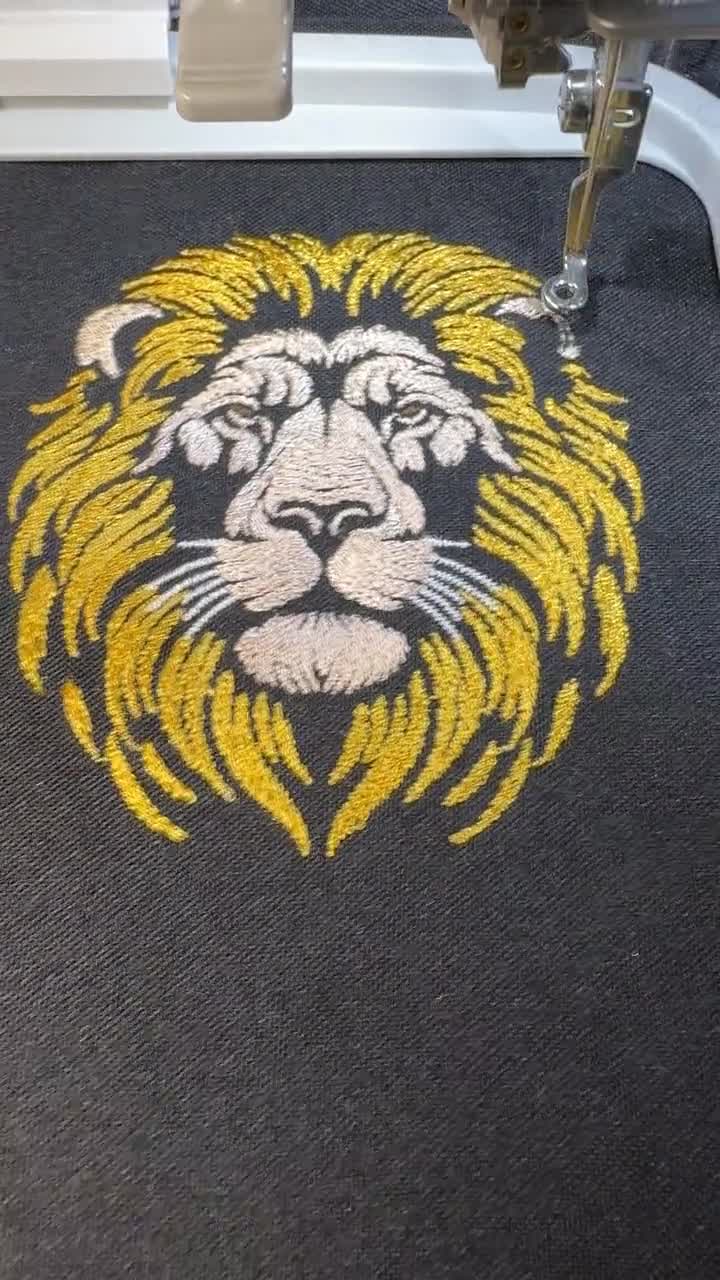 高貴なライオンの刺繍デザイン、金色のたてがみ、暗い色の生地に飾る