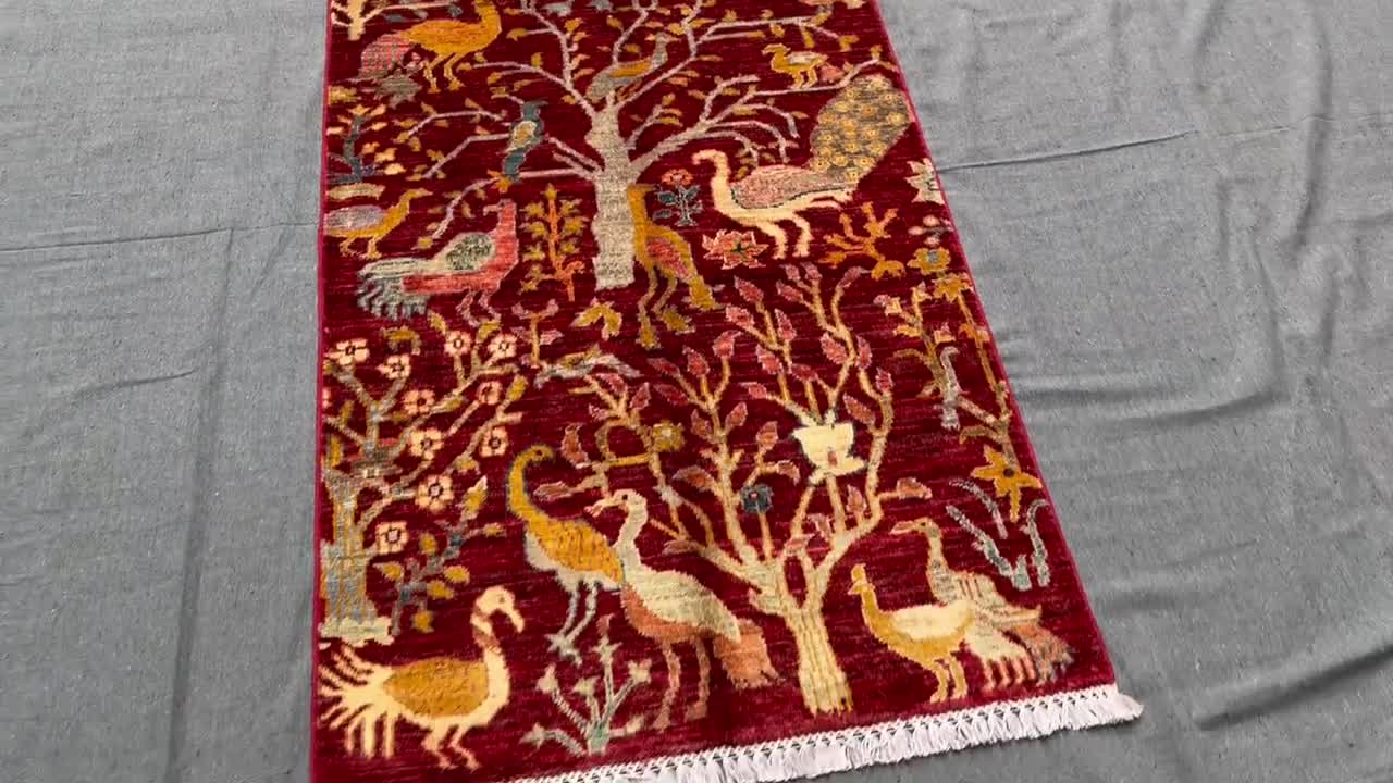 鳥と木のデザインが施された手作りの赤いペルシャ絨毯 - 職人の手仕事