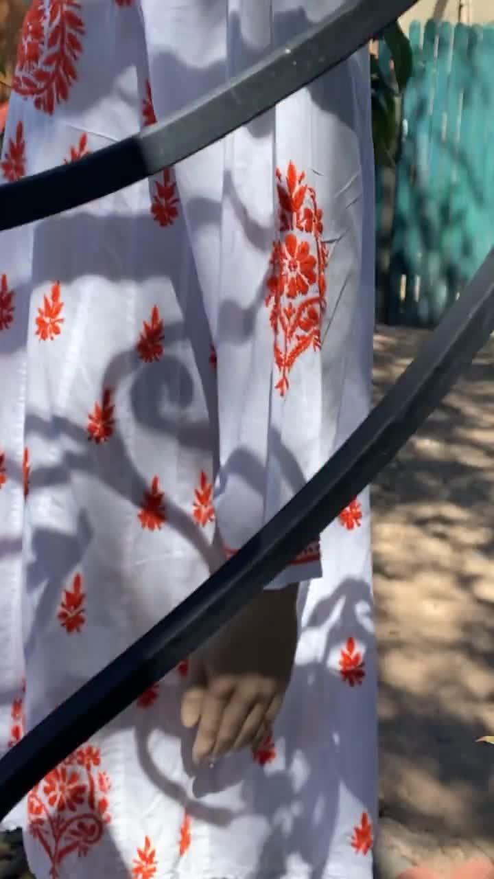 Hand embroidered white cotton dress, with orange yarn embroidery. Long  sleeves, knee length.