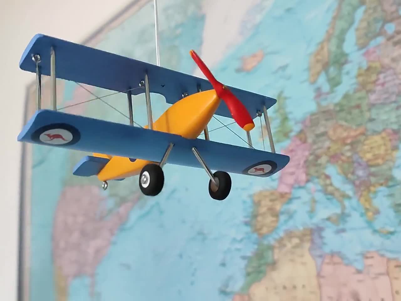 Aeroplano in miniatura e accessori da viaggio su sfondo giallo