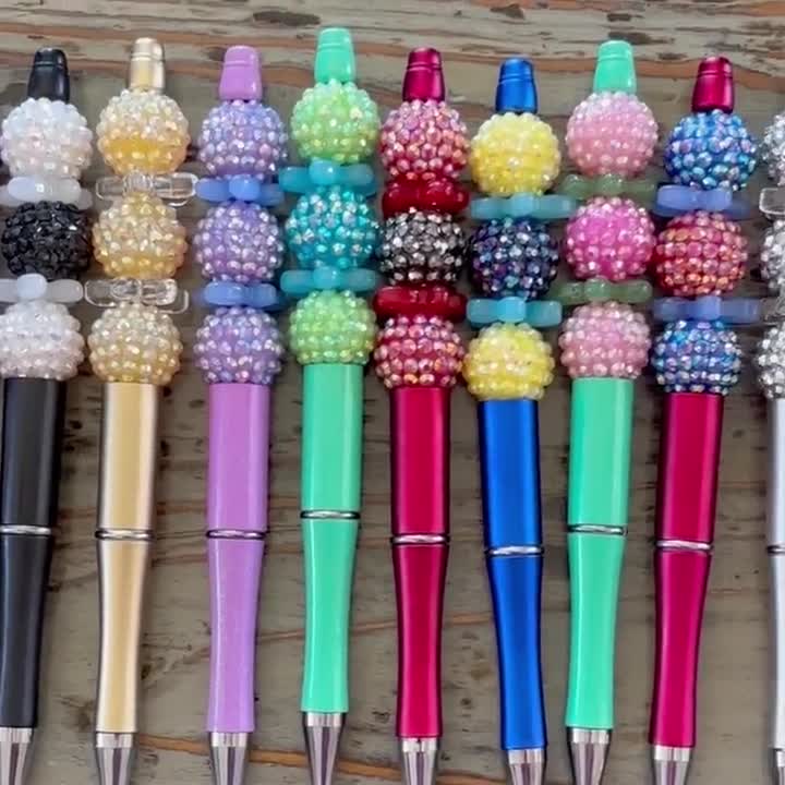 ガラスビーズペン、キラキラ光るボール、そして花が描かれた黒の