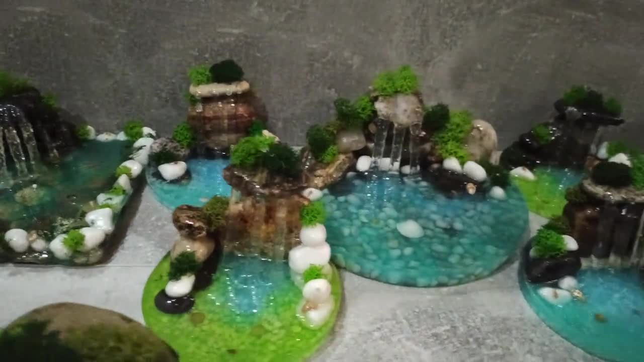 First attempt at a Faux Waterfall Terrarium. Water is glow in the dark!  Products used: Fishbowl, polymer clay, uv resin, epoxy resin, sand, fake  moss, Perfect Cast plaster, tan paint, hot glue. 