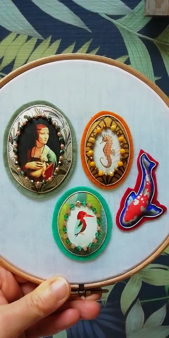 Broche bordado a mano en tela de fieltro, cuero, cuentas Miyuki y detalles facetados, borde con borde dorado, La dama del armiño de Leonardo da Vinci. video poster
