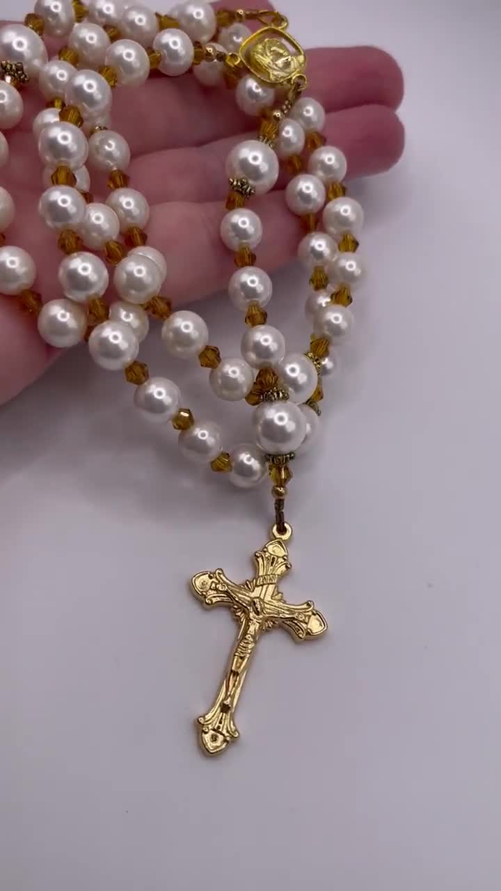Rosario con crucifijo dorado, perlas blancas y cristales color champán. video poster