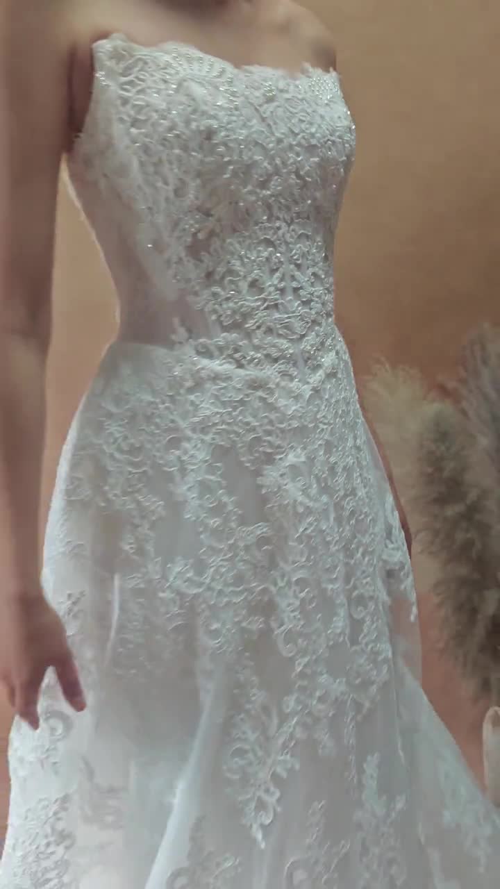 Vestido de novia de encaje con cintura vasca y sin tirantes video poster