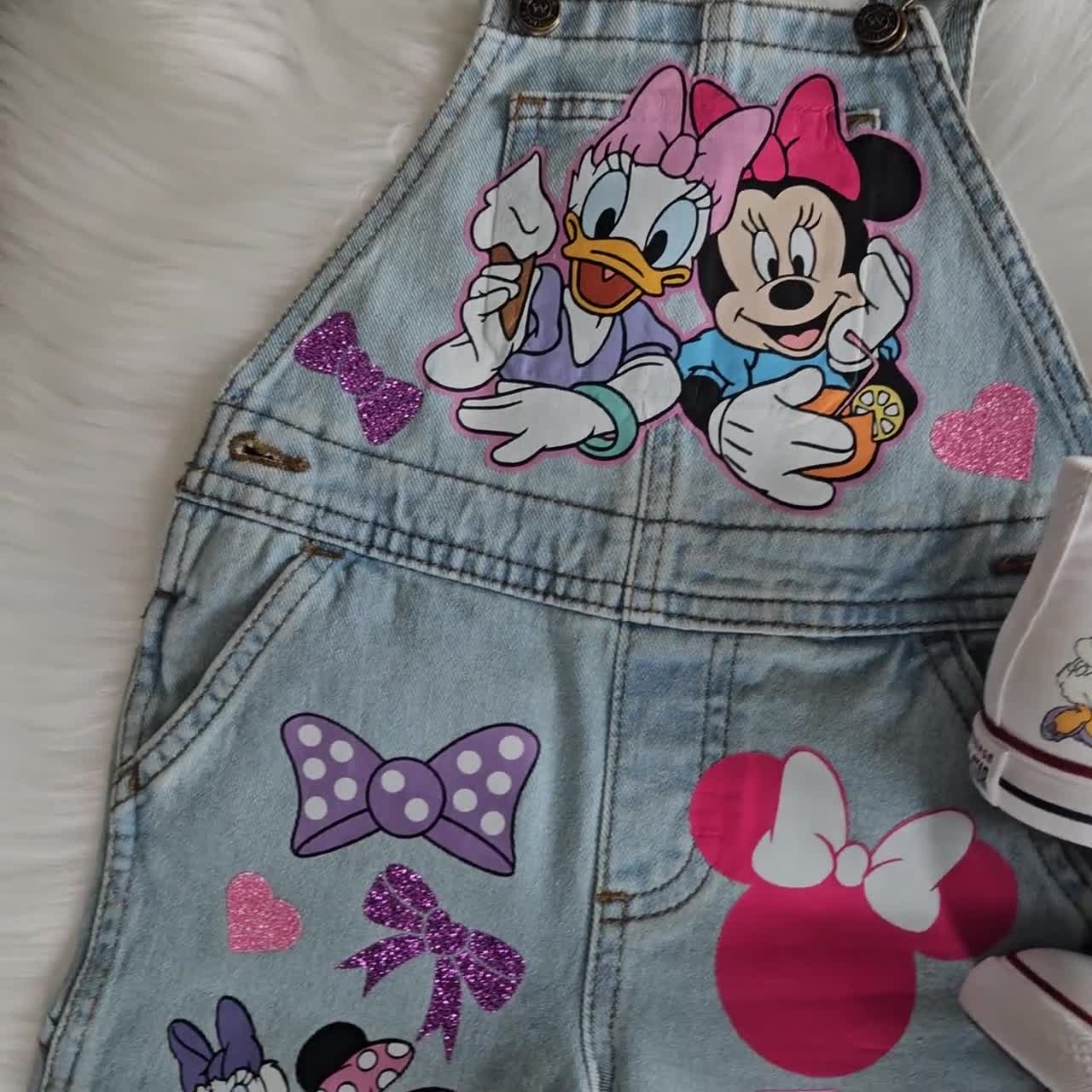 Mono de Daisy Duck y Minnie Mouse. Conjunto de mezclilla con lazo de Minnie. Zapatillas Converse a juego disponibles. video poster